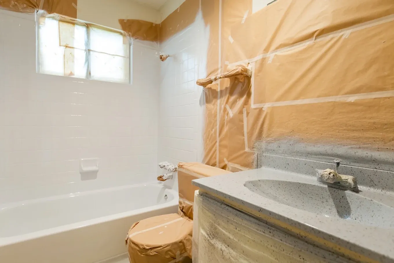 Bathtub and vanity masked off, room papered, ready to coat