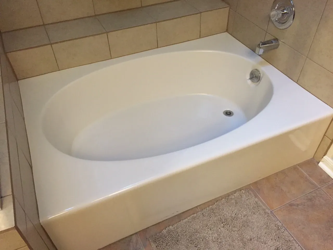 Bathtub refinished in white inside a tile surround