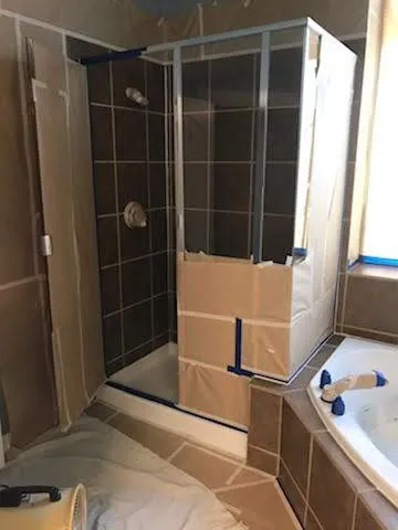 Brown tile shower stall beside the tub, before