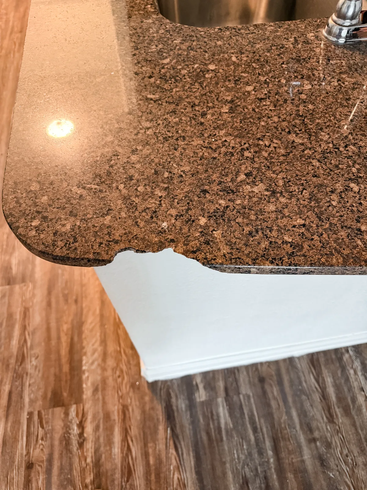 Chipped corner on a brown granite-look countertop