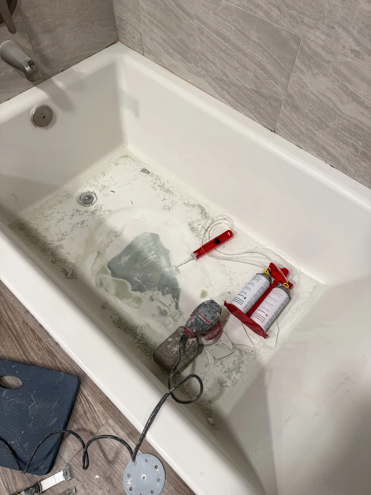 Repair patch being sanded flush to the tub floor