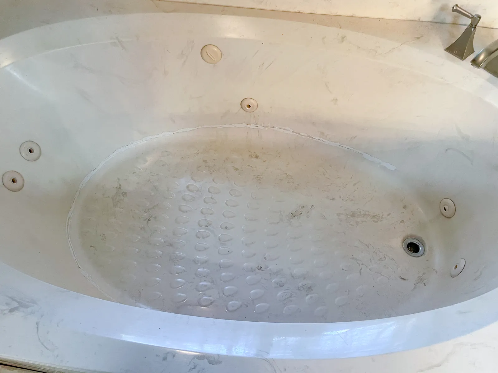 Close-up of a jetted tub jet with mold and grime around it