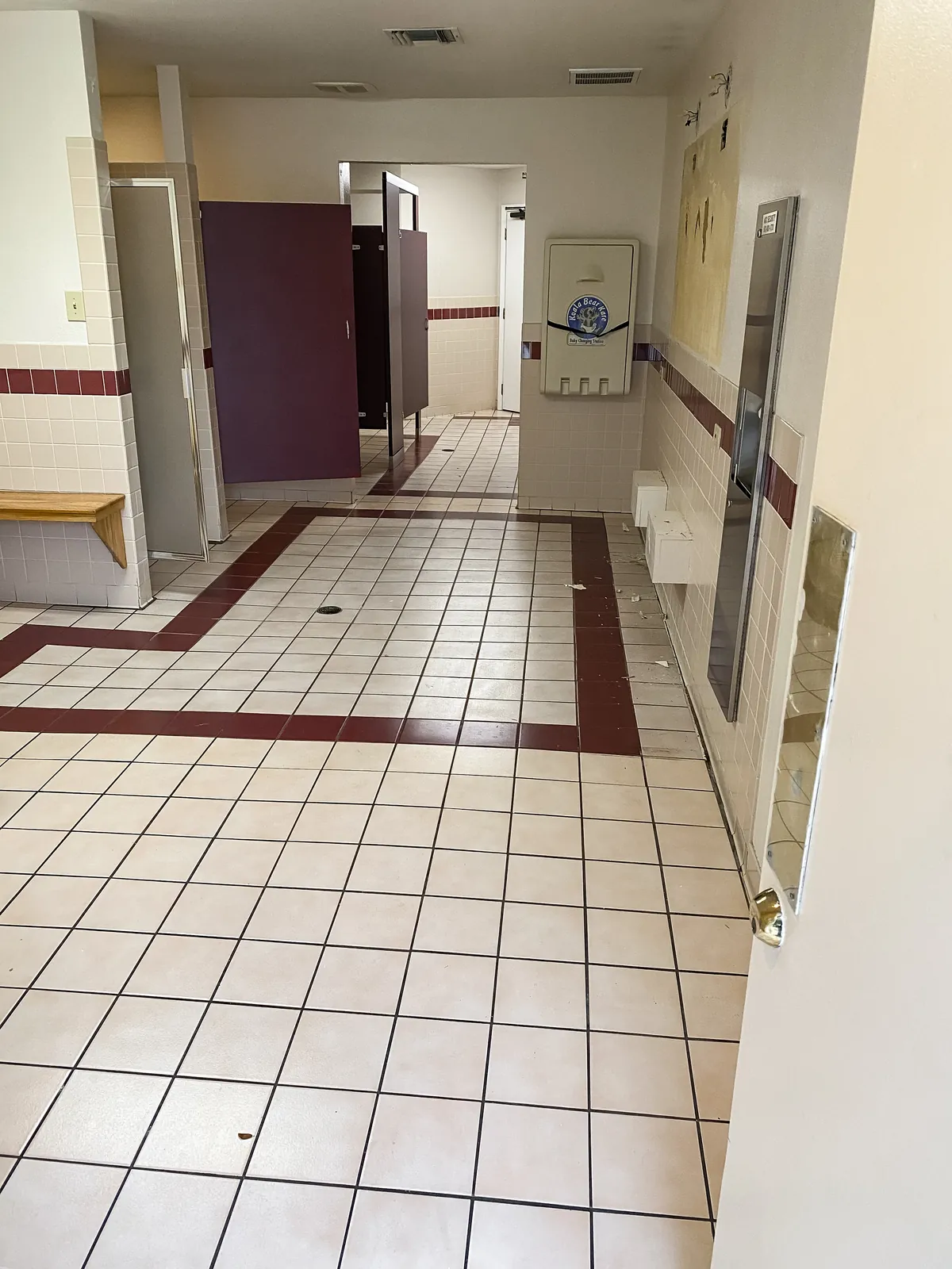 Locker room tile floor with maroon border, before