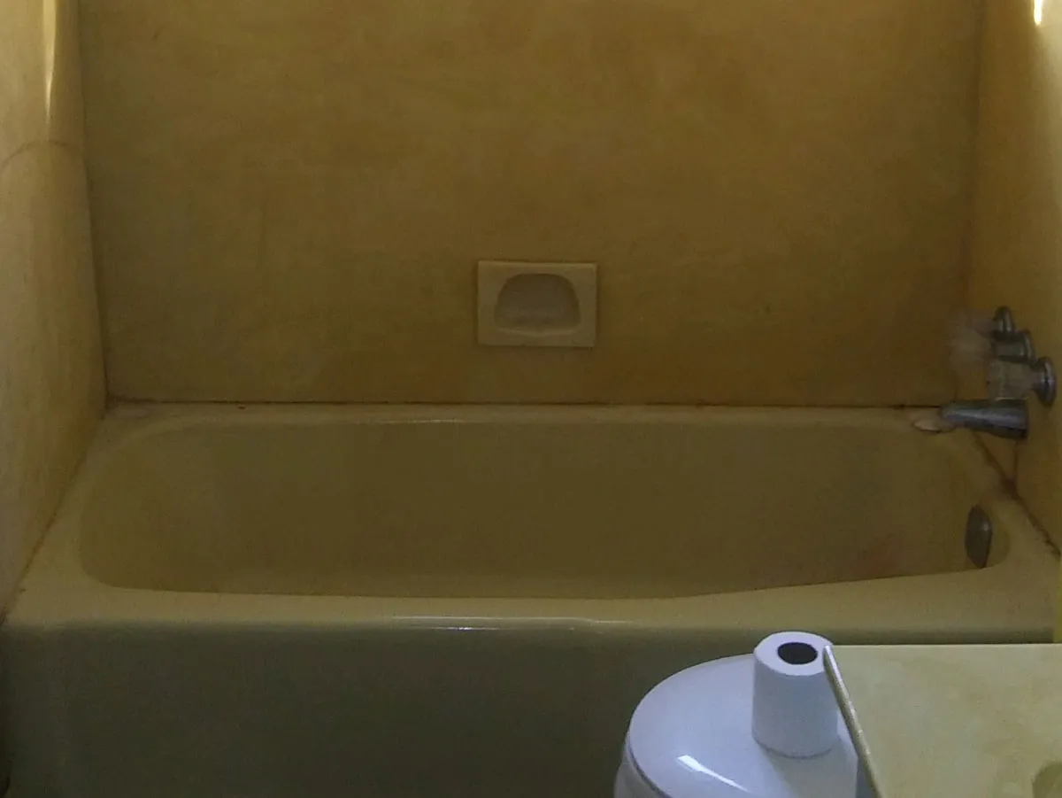 Yellowed alcove bathtub before refinishing